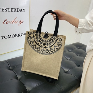 Detail of bohemian jute tote bag featuring mandala print and black rope handles