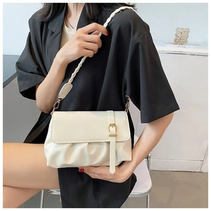Detail of cream white shoulder bag featuring braided strap and elegant pleated base