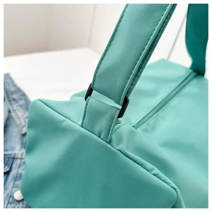 Détail de la couture de la bandoulière en nylon vert menthe et de la boucle noire