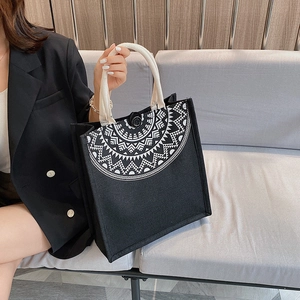 Detail of black canvas tote bag featuring ethnic geometric print and thick cotton rope handle