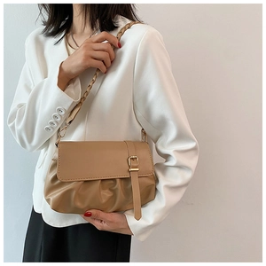 Detail of tan pleated PU leather shoulder bag with gold metal buckle and woven strap
