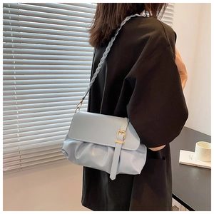Close-up of light blue pleated underarm bag with unique braided strap and gold metal buckle
