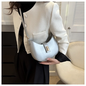 Détail d'un sac à bandoulière demi-lune argenté avec finition métallique et boucle dorée