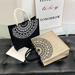 Detail of linen tote bags with geometric patterns and sturdy rope handles on a bench