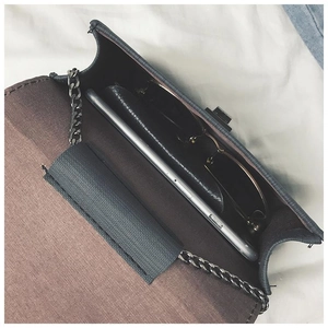 Top view of compact crossbody bag showing brown lining with phone and sunglasses inside