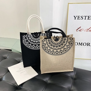 Detail view of ethnic tote bags with mandala patterns and woven rope handles