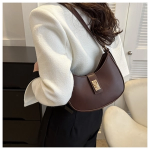 Détail d'un sac demi-lune marron foncé rétro avec fermoir métallique doré élégant