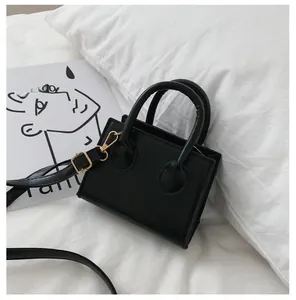 Detail view of mini black leather tote with gold hardware and adjustable strap