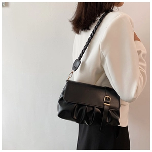 Black ruched cloud bag featuring elegant woven strap and gold hardware on model