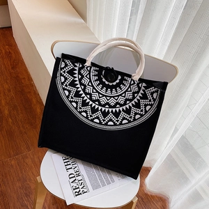 Detail of minimalist canvas tote with white geometric pattern and thick cotton rope handles