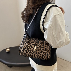 Stylish leopard print shoulder bag with gold metal clasp shown on a model's shoulder