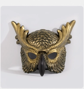 Close-up of antique gold owl mask with detailed feather textures for cosplay party