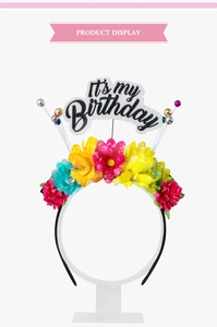Détail d'un serre-tête floral coloré avec texte brillant pailleté 'IT'S MY BIRTHDAY'