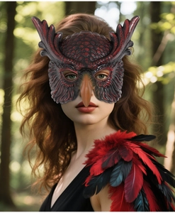 Detailed view of owl mask with matching red feather shoulder pieces on a forest backdrop