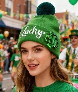 Detail of green St. Patrick's Day knit hat with Lucky embroidery and sequin clover leaf