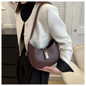 Détail du sac sous le bras demi-lune marron foncé avec boucle dorée et texture cuir