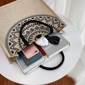 Macro shot of large capacity jute tote bag with geometric print and rope handles on a table