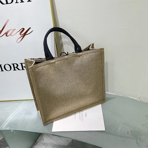 Detail of natural linen tote bag showing woven fabric texture and black ribbon handle