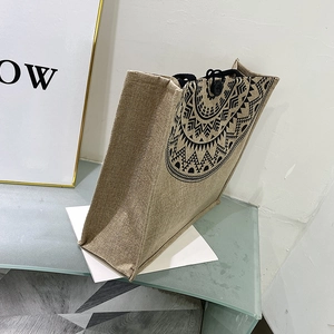 Detail of jute tote bag showing ethnic geometric pattern and sturdy black woven handle