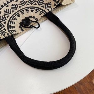 Macro detail of canvas tote bag featuring tribal print and black rope handles