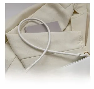 Close-up of sleek white shoulder strap and metal hardware on a French baguette bag