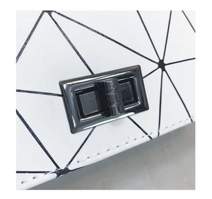 Dettaglio della borsa bianca a tessere geometriche con chiusura a scatto in metallo nero