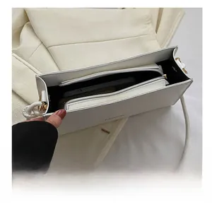 Macro shot showing large storage capacity and interior zipper pocket of this white baguette bag