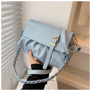 Detail of light blue cloud bag featuring pleated PU leather and a woven shoulder strap
