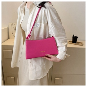 Detail of rose pink faux leather bag with knotted shoulder strap and Fashion text
