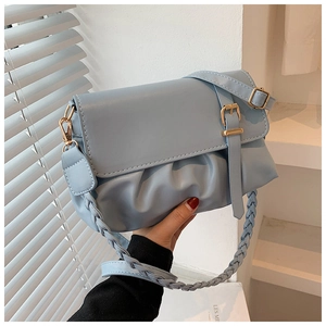 Detailed view of light blue leather handbag with pleated design and vintage gold buckle