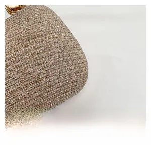 Close-up of champagne gold sequin texture with elegant metal buckle on a fashion bag