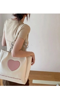 Detail of cream tote bag with pink heart embroidery and large metal chain strap link