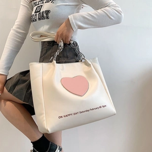 White faux leather tote bag with pink heart patch and silver chain strap