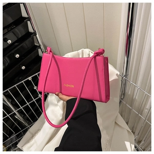 Detail of fuchsia rectangular shoulder bag featuring gold FASHION lettering and slim straps