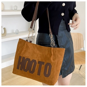 Detail view of large tote bag with fuzzy texture and HOOTO letter print and chain strap