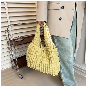 Detailed close-up of light yellow puff cloud tote bag with unique bubble pleat texture