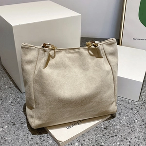 Detail of the suede texture and gold metal ring handle on this oversized tote bag