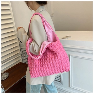 Lifestyle view of pink puffy cloud tote bag with pleated texture worn on shoulder