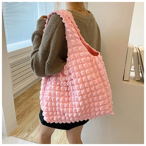 Pink bubble textured shoulder bag for women shown in a modern lifestyle setting