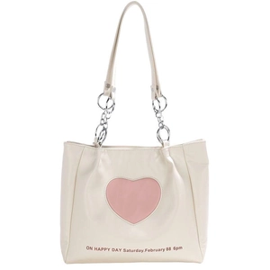 Creamy white tote bag with pink heart design and silver chain straps on white background