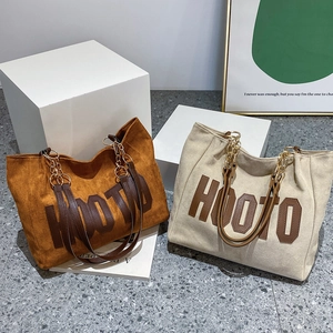 Detail of wool fabric tote bag with HOOTO letter patch and metal chain leather strap