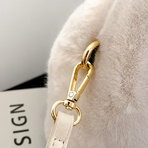 Détail du crochet en métal doré sur le sac à bandoulière en peluche beige