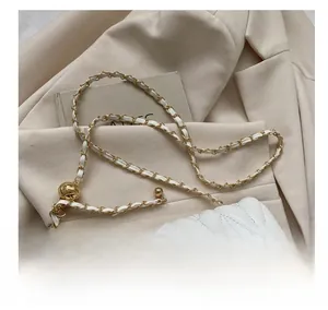 Détail du sac à bandoulière matelassé blanc avec boucle dorée et bandoulière chaîne