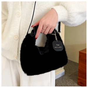 Détail de la texture en fausse fourrure noire avec chaîne dorée sur ce sac à main chic