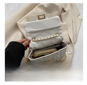 Vue détaillée de l'intérieur spacieux d'un sac blanc matelassé avec une chaîne dorée
