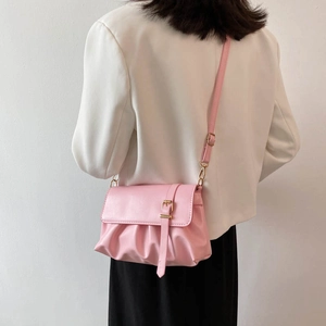 Pink matte PU leather pleated cloud bag with gold buckle on a white blazer model