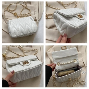 Détail d'un sac bandoulière blanc matelassé avec chaîne dorée et bille de réglage