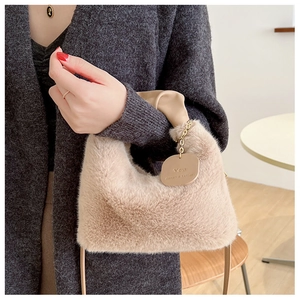 Détail du sac en fausse fourrure pelucheuse avec poignée chaîne et étiquette en cuir