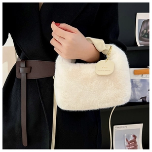 Détail du sac à bandoulière en peluche blanche avec poignée en cuir et décor de chaîne