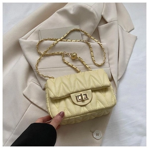 Détail du sac bandoulière jaune clair matelassé avec chaîne dorée et fermoir métal